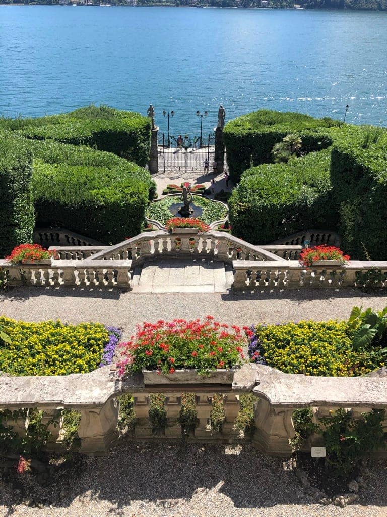 What to see in Villa Carlotta: The panoramic balcony view over the Italian gardens toward Lake Como and Bellagio.