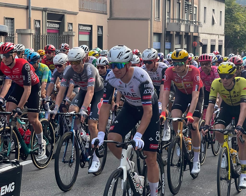 Professional cyclists in the Il Lombardia race climbing one of the hills in Como with autumn leaves in October.
