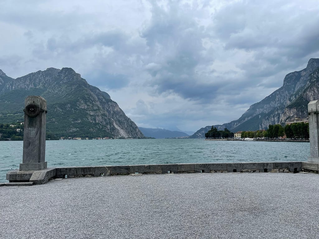 Sunny day at the Lecco waterfront with a view of the lake and surrounding Italian Alps.