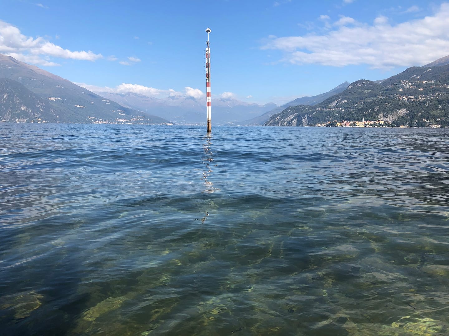 View from Punta Spartivento in Bellagio, with Lake Como's water in the foreground and mountains on both sides